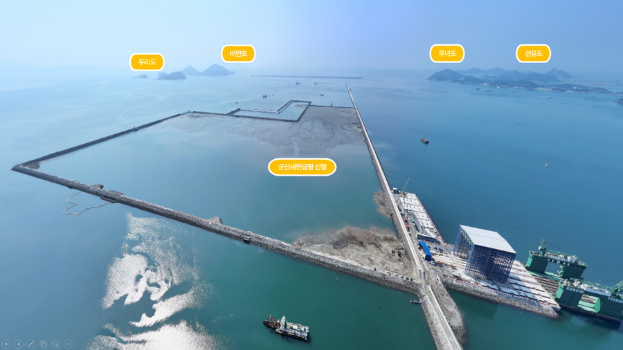 군산 새만금 공항 신항만 일대를 드론으로 촬영한 전경 이미지. 방조제와 항만 공사 구역이 보이며, 멀리 두리도·비안도·무녀도·선유도 등 섬들이 표시되어 있다